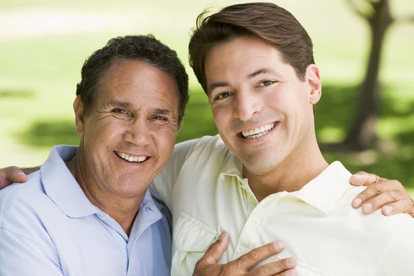 Zwei Männer im Freien, die sich umarmen und lächeln — Stockfoto