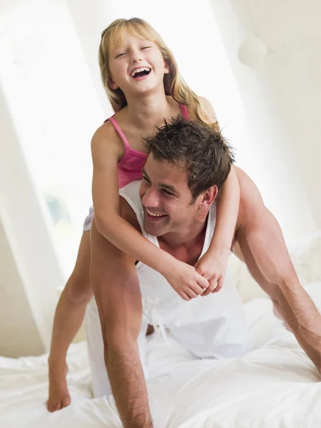 男人和年轻女孩躺在床上玩和微笑 — 图库照片