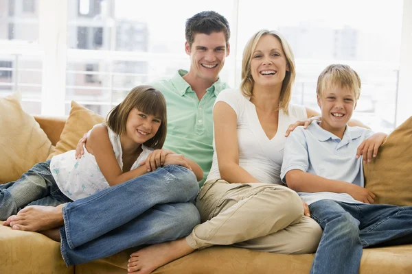 リビング ルームの笑みを浮かべて座っている家族 — ストック写真