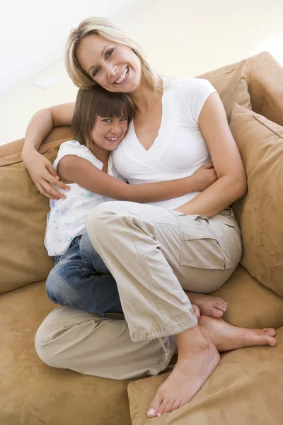 Kobieta i młody dziewczyna siedzi w salonie uśmiechający się — Zdjęcie stockowe