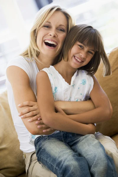 Frau und junges Mädchen im Wohnzimmer lächelnd — Stockfoto