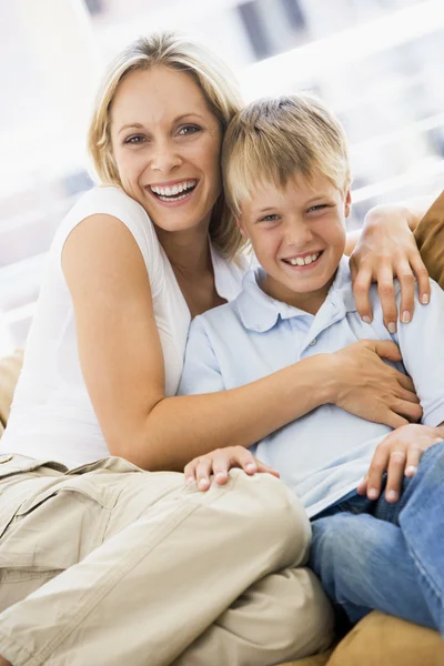 Женщина и мальчик сидят в гостиной и улыбаются — стоковое фото