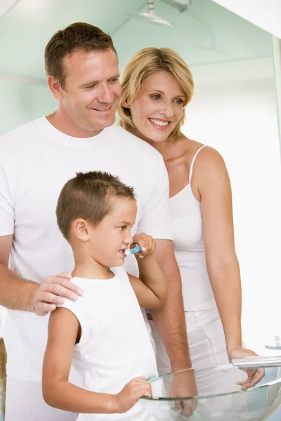 Paar in badkamer met jonge jongen tanden poetsen — Stockfoto