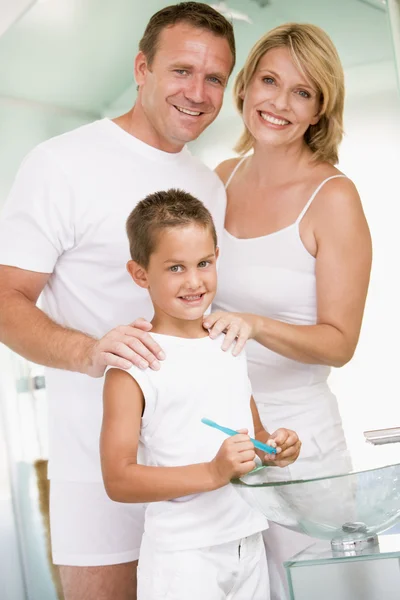 Paar in badkamer met jonge jongen tanden poetsen — Stockfoto