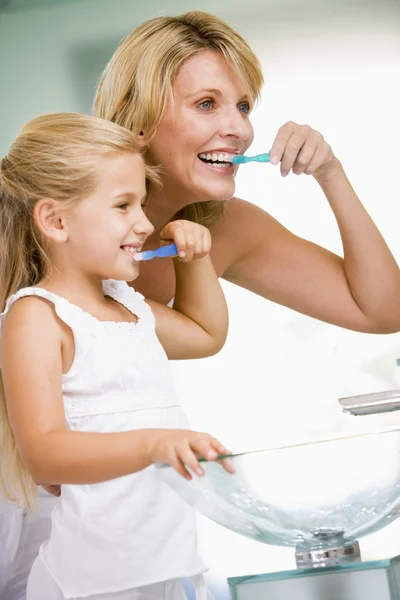 Vrouw en jonge meisje in badkamer tanden poetsen — Stockfoto