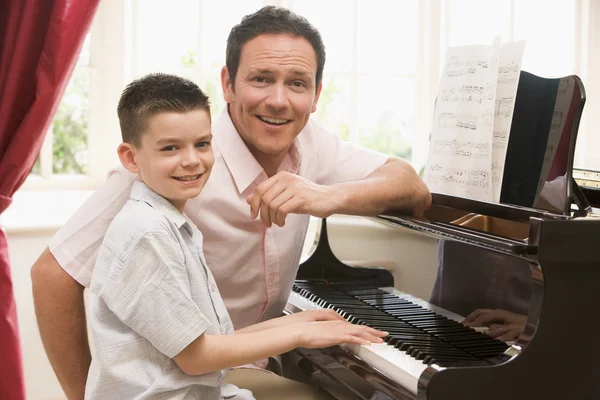 再生ピアノと笑みを浮かべて男と若い少年 — ストック写真