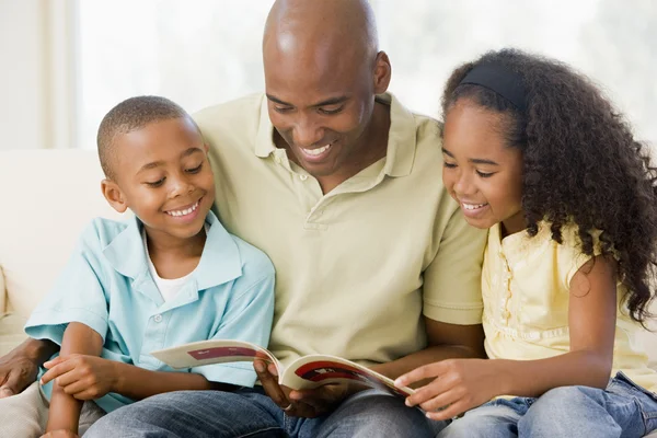 男人和两个孩子坐在客厅里读的书和 Smi — 图库照片