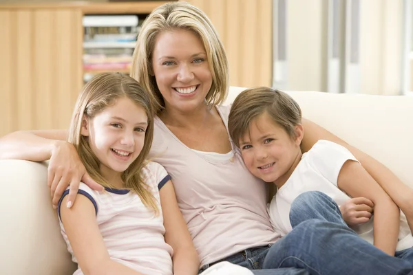 Vrouw en twee kinderen in de woonkamer glimlachen — Stockfoto