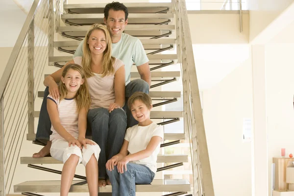 Familj sittande i trappan leende — Stockfoto