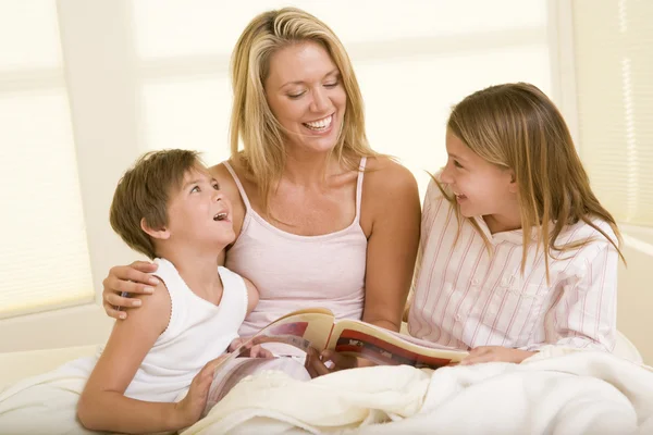Жінка Двома Маленькими Дітьми Сидить Ліжку Читаючи Книгу Смс — стокове фото