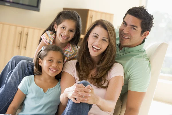 Семья сидящая в гостиной улыбается — стоковое фото