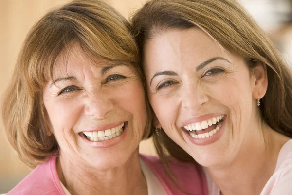 Zwei Frauen im Wohnzimmer lächeln — Stockfoto