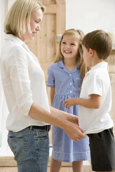 Woman in front hallway with two young children smiling — Stock Photo, Image
