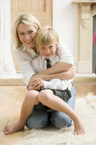 Vrouw in front hal knuffelen jongen en glimlachen — Stockfoto