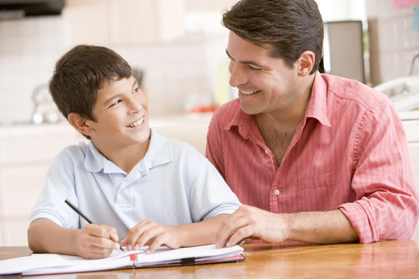 Mann Hilft Jungen Küche Bei Hausaufgaben Und Lächelt — Stockfoto
