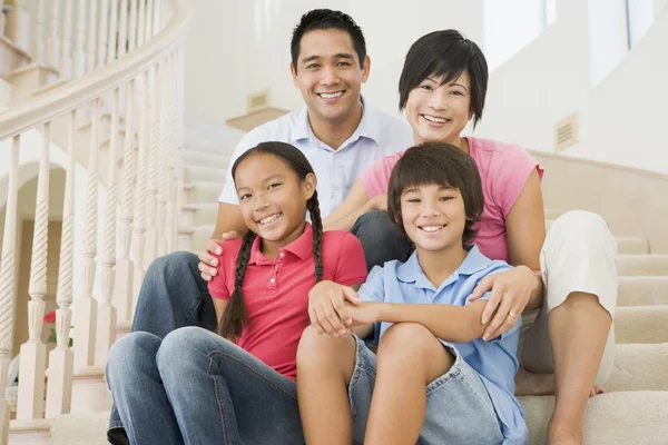 Rodina sedí na schodech a usmívá se — Stock fotografie