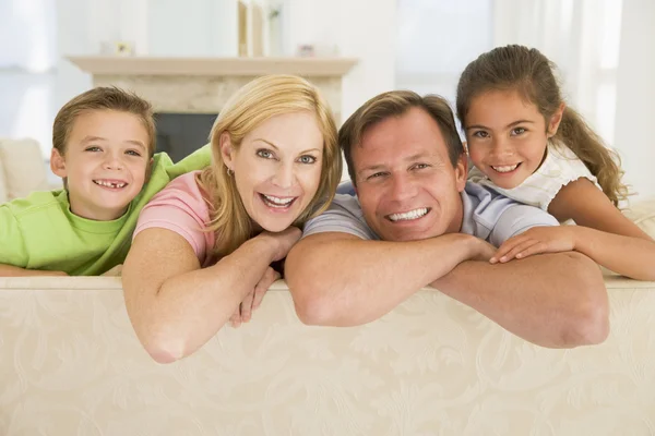リビング ルームの笑みを浮かべて座っている家族 — ストック写真