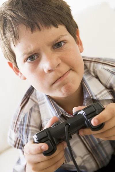 Jovem menino segurando controlador de jogo de vídeo parecendo confuso — Fotografia de Stock