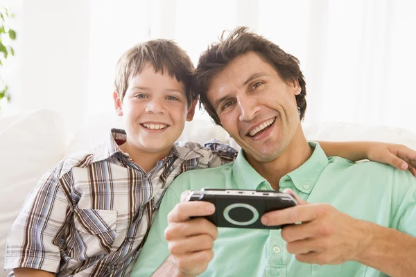 ハンドヘルド ゲーム笑みを浮かべて男と若い少年 — ストック写真
