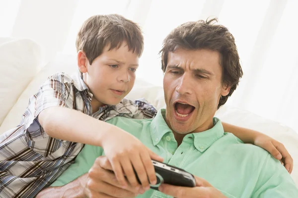 Jonge jongen nemen handheld spel van ongelukkig man — Stockfoto