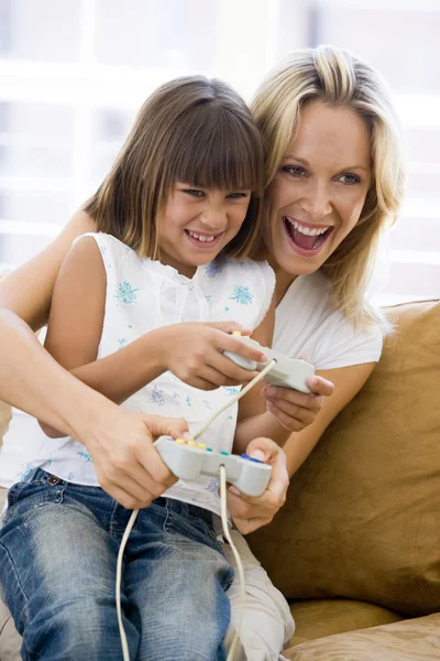 Vrouw en jonge meisje in woonkamer met video game controllers — Stockfoto