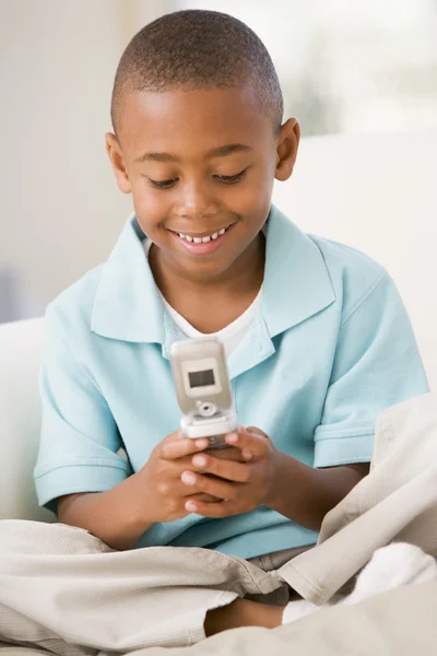 Молодий Хлопчик Вітальні Використовує Мобільний Телефон Посміхається — стокове фото