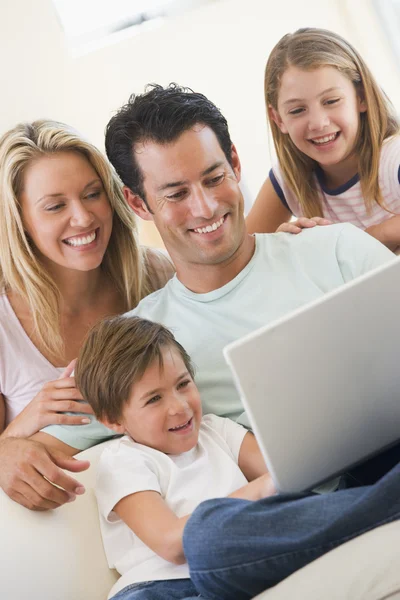 Familia en la sala de estar con portátil sonriendo — Foto de Stock
