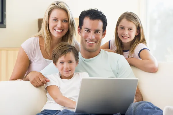 家庭在客厅与笔记本电脑微笑 — 图库照片