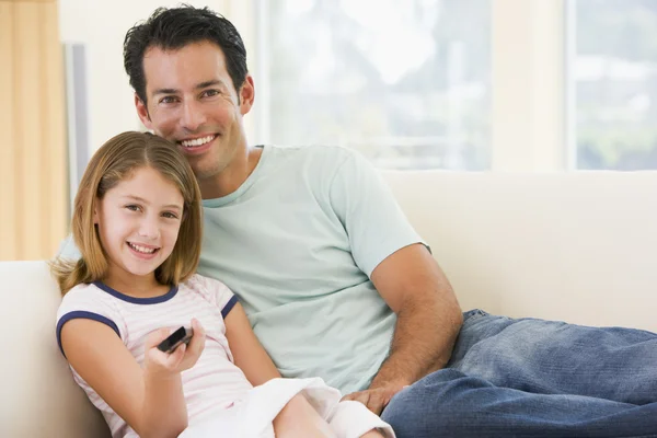 Homem e menina na sala de estar com controle remoto sorrindo — Fotografia de Stock
