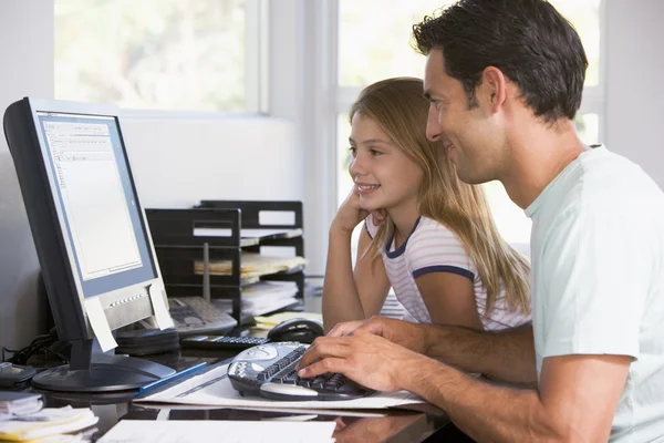 Άνθρωπος και νέους κορίτσι στο γραφείο στο σπίτι με τον υπολογιστή χαμογελώντας — Φωτογραφία Αρχείου
