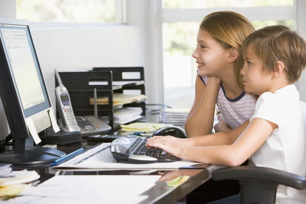 年轻的男孩和年轻女孩在与计算机微笑的家庭办公室 — 图库照片