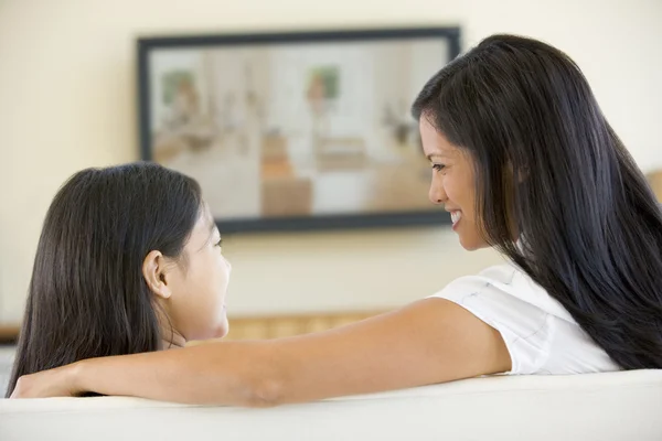 Vrouw en jonge meisje in woonkamer met flat screen televisie — Stockfoto
