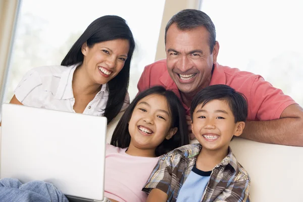 家庭在客厅与笔记本电脑微笑 — 图库照片