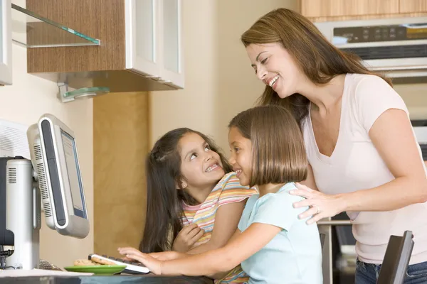 Woman Two Young Girls Kitchen Computer Smiling — Stock Photo, Image