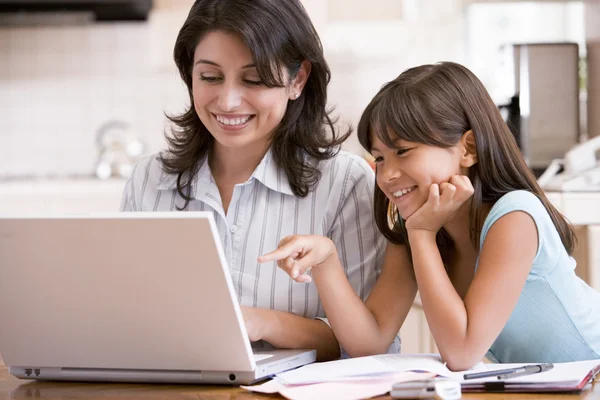厨房用的笔记本电脑和文书工作微笑的女人和年轻女孩 — 图库照片