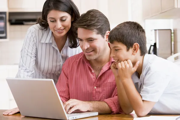 Família na cozinha com laptop sorrindo — Fotografia de Stock