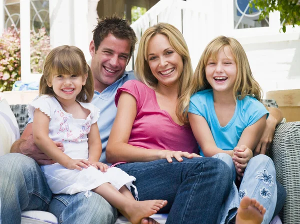 Familjen sitter på uteplatsen leende — Stockfoto