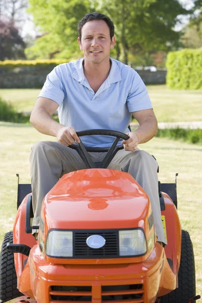 芝刈り機の笑みを浮かべて屋外運転の男 — ストック写真