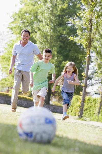 男人和两个年幼的孩子户外踢足球和有福 — 图库照片