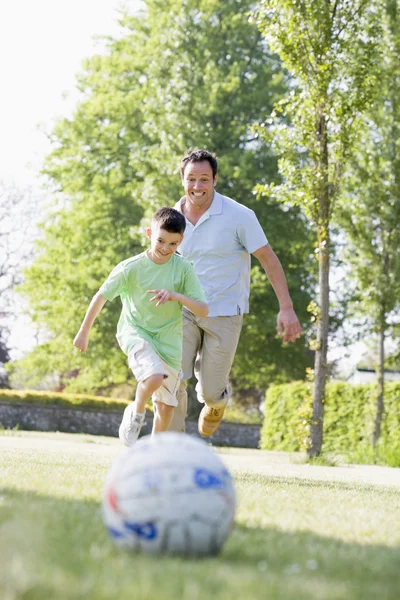Uomo e giovane ragazzo all'aperto a giocare a calcio e divertirsi — Foto Stock
