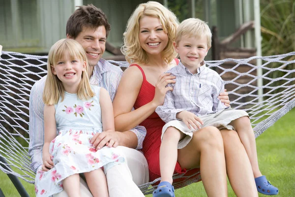 Familjen sitter i hängmatta leende — Stockfoto