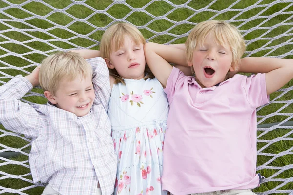Troje dzieci, relaks i śpi w hamaku — Zdjęcie stockowe