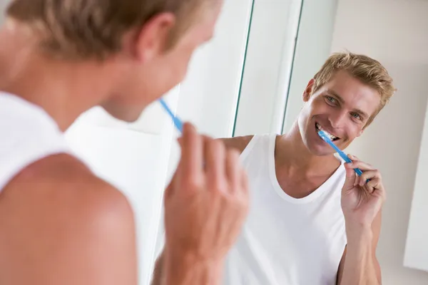 Ο άνθρωπος στο μπάνιο βουρτσίζει τα δόντια και χαμογελά — Φωτογραφία Αρχείου