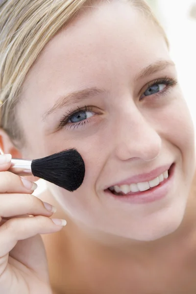 Mujer con cepillo de maquillaje sonriendo — Foto de Stock