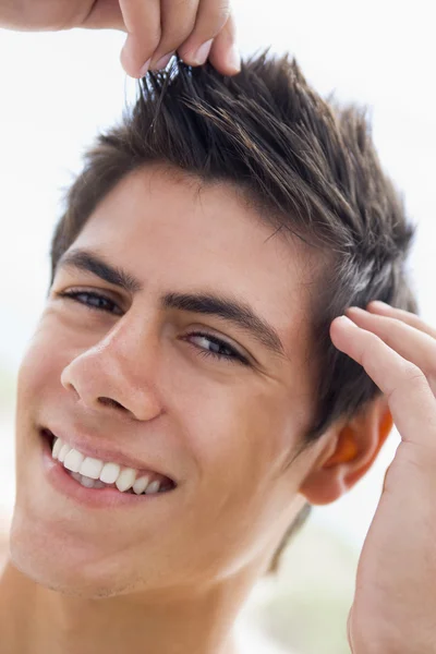 Homem brincando com o cabelo sorrindo — Fotografia de Stock