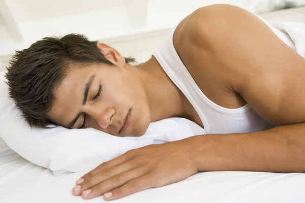 Homem deitado na cama dormindo — Fotografia de Stock