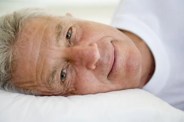 Seorang pria berbaring di tempat tidur — Stok Foto
