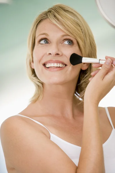 Mulher com escova de maquiagem sorrindo — Fotografia de Stock