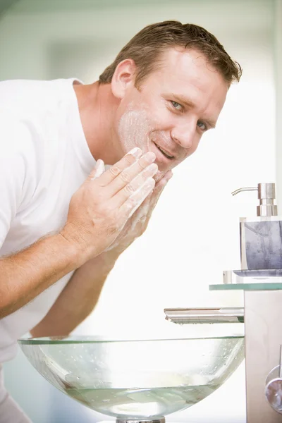 Мужчина в ванной моет лицо — стоковое фото