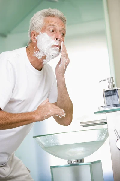 Мужчина в ванной бриться — стоковое фото